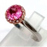 An 18k rose gold and platinum ring with a natural unheated 1.25ct pink sapphire with a halo of round