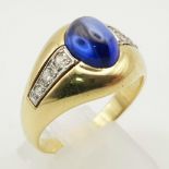 An 18K Yellow Gold Blue Opal and Diamond Gents Ring. Central blue opal cabochon with two wings of