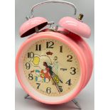 A PINK VINTAGE DOUBLE BELL ALARM CLOCK WITH DOG MOTION MOVING HEAD. HEIGHT 17.5CM. IN WORKING ORDER.