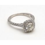 An 18K White Gold Diamond Ring. A brilliant round-cut central diamond of 0.8ct surrounded by a