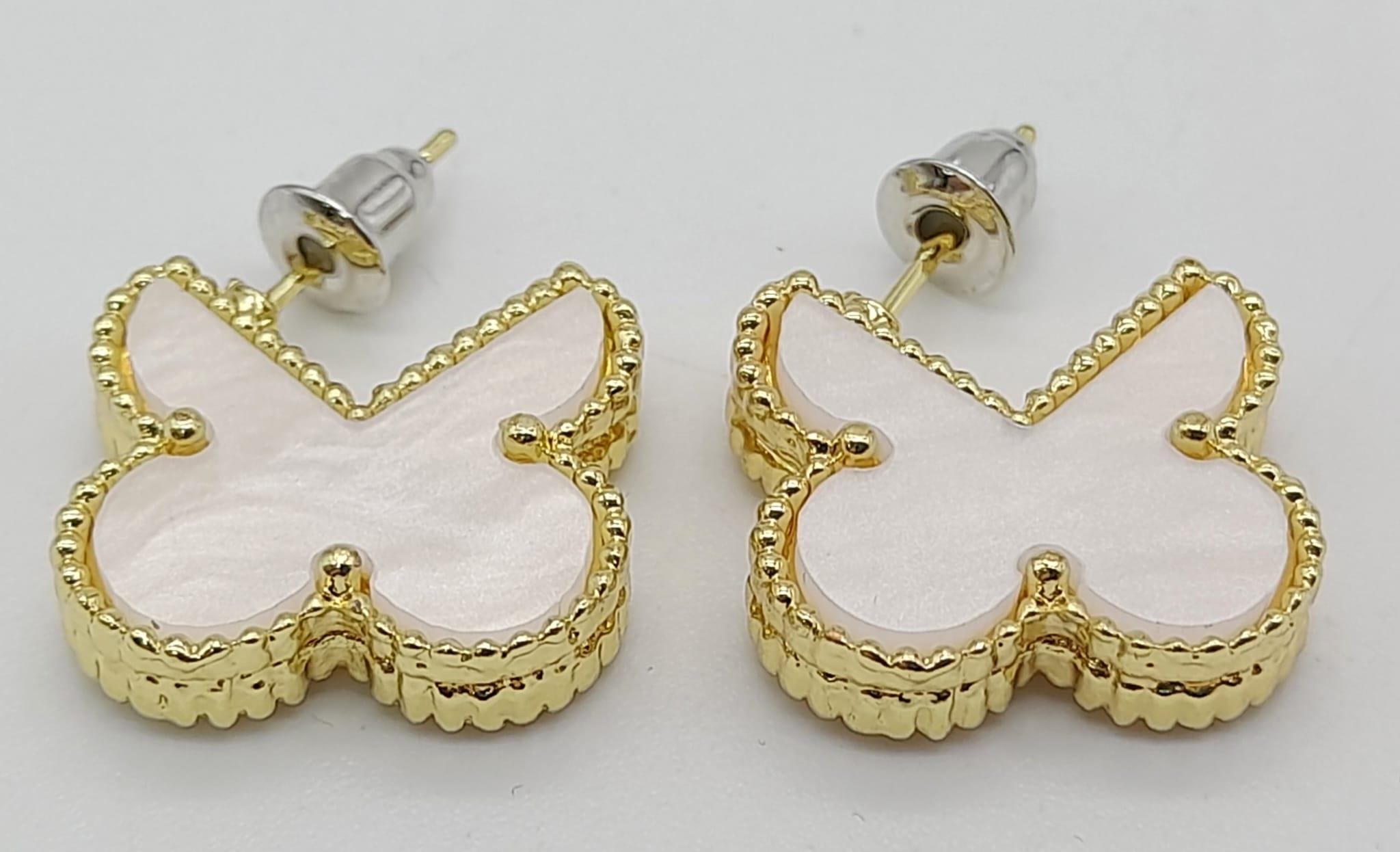 A pair of gold tone and mother of pearl butterfly earrings. Weight: 6 g.