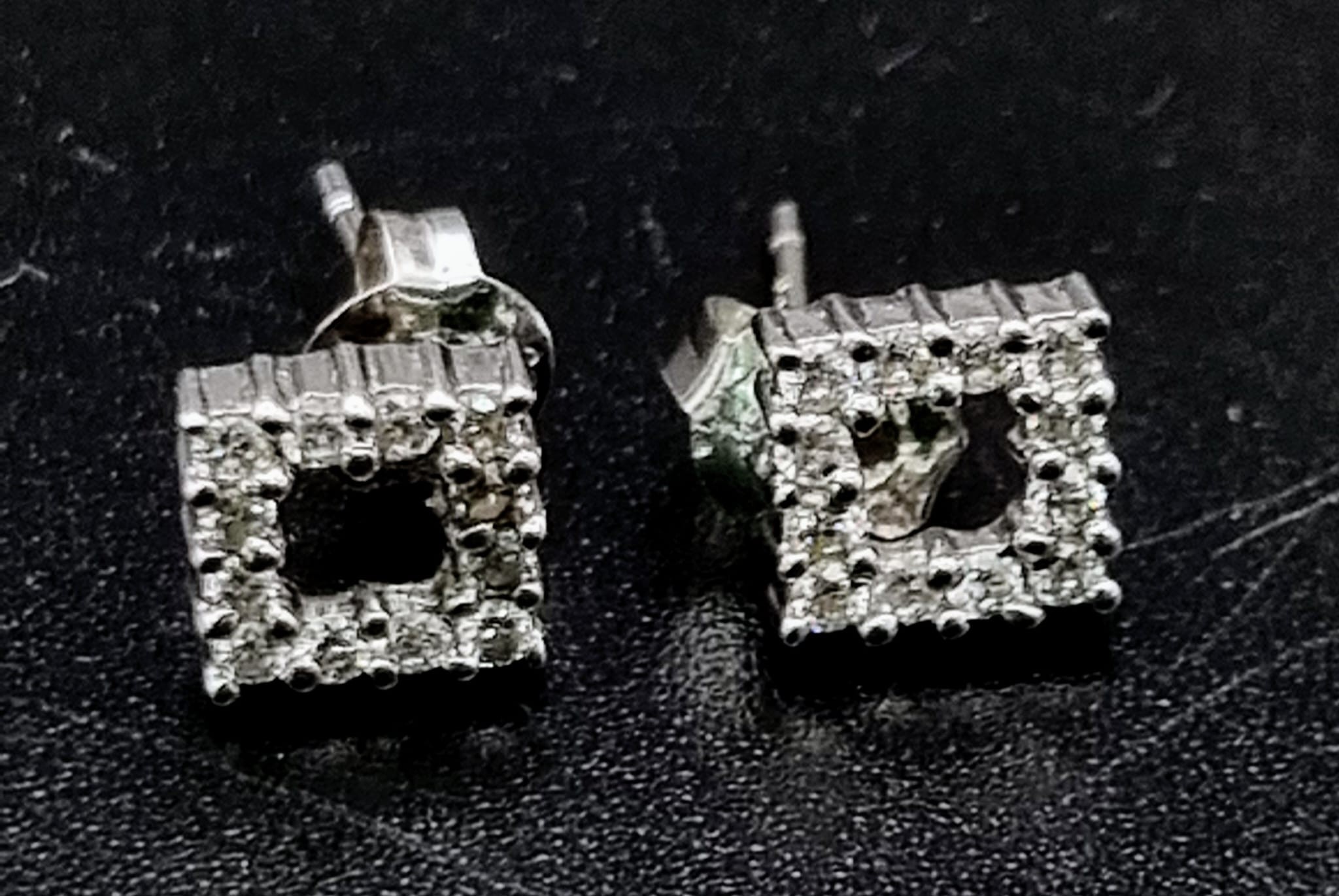 An 18K white gold pair of stud earrings with a square cluster of diamonds (0.25 carats). total