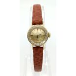 A DAINTY VINTAGE 18K GOLD LADIES OMEGA WRIST WATCH ON THE ORIGINAL OMEGA LEATHER STRAP. MANUAL
