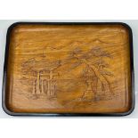A wooden tray with relief carving of Itsukushima Shinto Shrine in Japan. It depicts the Torii (