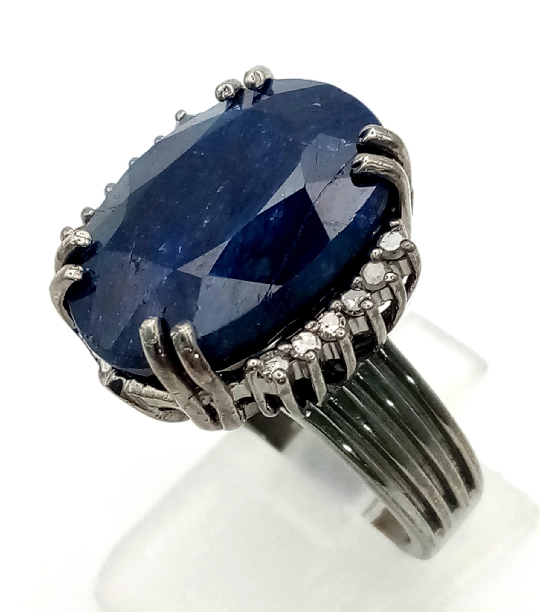 A 20.30ct Oval cut Natural Blue Sapphire Ring set in 925 silver, decorated with 0.20ct Diamond