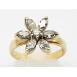 An 18K Yellow Gold Diamond Flower Ring. Central round diamond surrounded by six oval petal