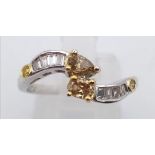 An 18K white gold twist ring with clear baguette and champagne round cut diamonds ((0.58 carats).