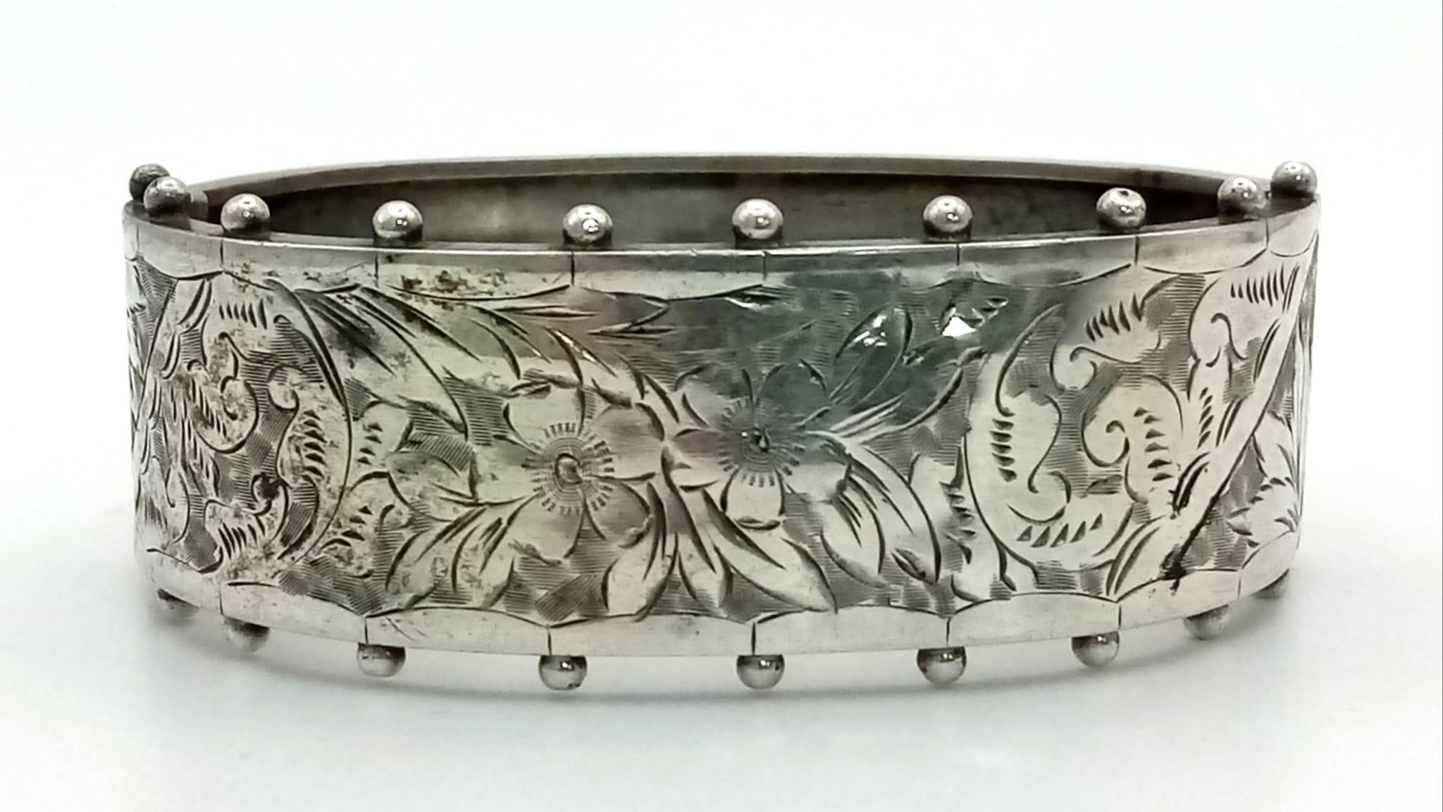 A Victorian Sterling Silver Floral and Foliate Engraved Bangle. 17g. 23mm width.