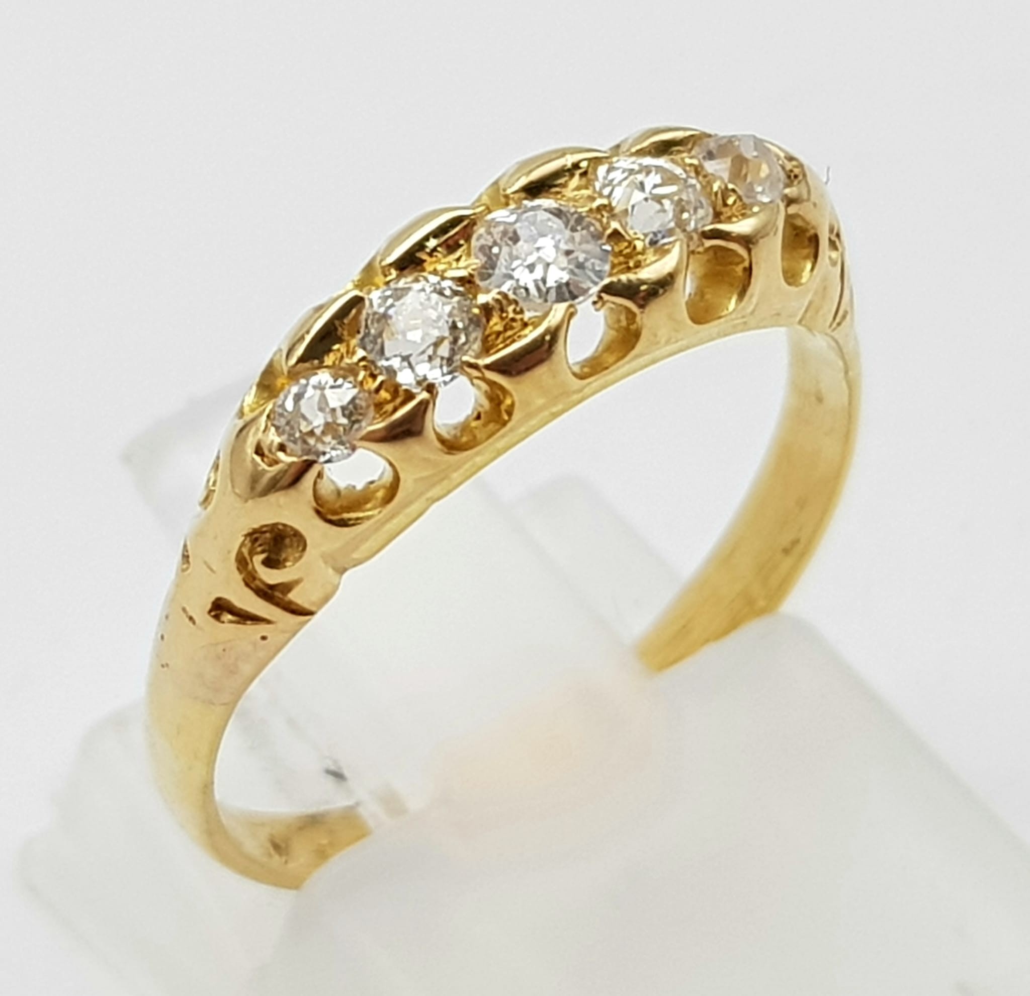 An Antique High Karat Five Diamond Ring. Five bright white, round-cut graduating stones. Size L. 2.