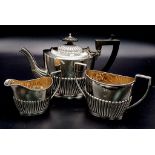 AN ART DECO SOLID SIVER TEA SET HALF FLUTED DESIGN WITH TEA POT, SUGAR BOWL AND CREAMER . HALLMARKED