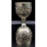 A SOLID SILVER DOUBLE ENDED TOASTING GOBLET WITH HAND CHASED VILLAGE LIFE DECORATION. 70.8g, 11cms