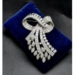 A 6ct Diamond and Platinum Bow Brooch. Brilliant cut baguette, round cut and encrusted diamonds