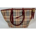 A Classic Burberry Small Tote Bag with Dust Cover. Gilded hardware. Inner Red liner with zipped