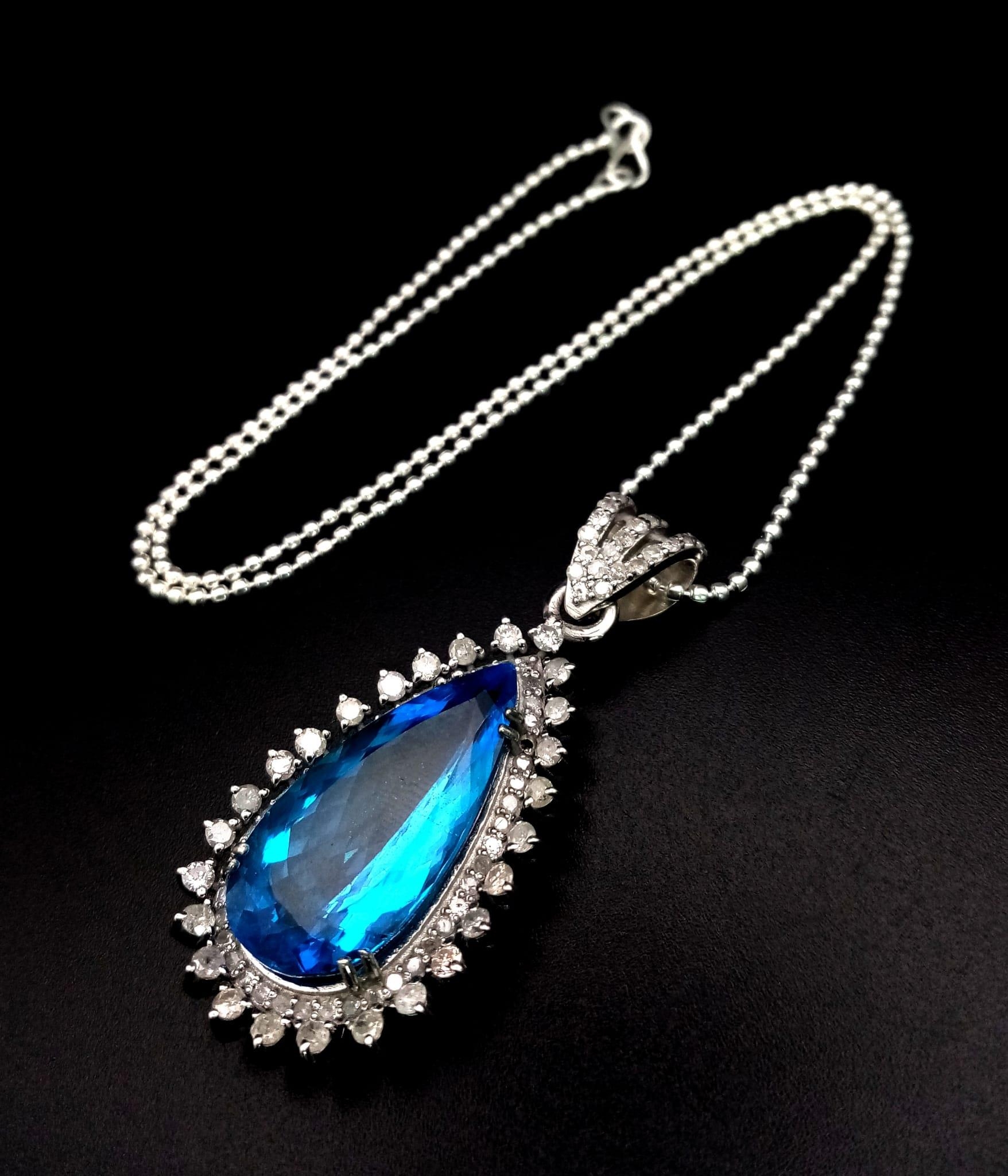 A Natural 10cts Pear cut Blue Topaz Drop Pendant, set in 925 silver decorated with 1.50cts