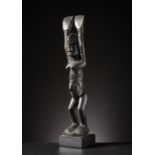 Dogon o Tellem - Mali Nommo figure with arms raised.Hardwood with dark patina.Defects and signs of