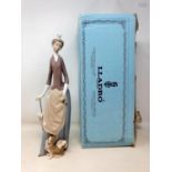 A Lladro figure of a lady with a dog, 30 cm high, boxed