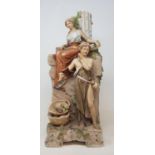 A Royal Dux figural group of a young man and woman perched on a ruin, and a Continental figural