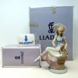 A Lladro figure of a girl with a dog, 21 cm high, boxed and a Lladro plaque (2)