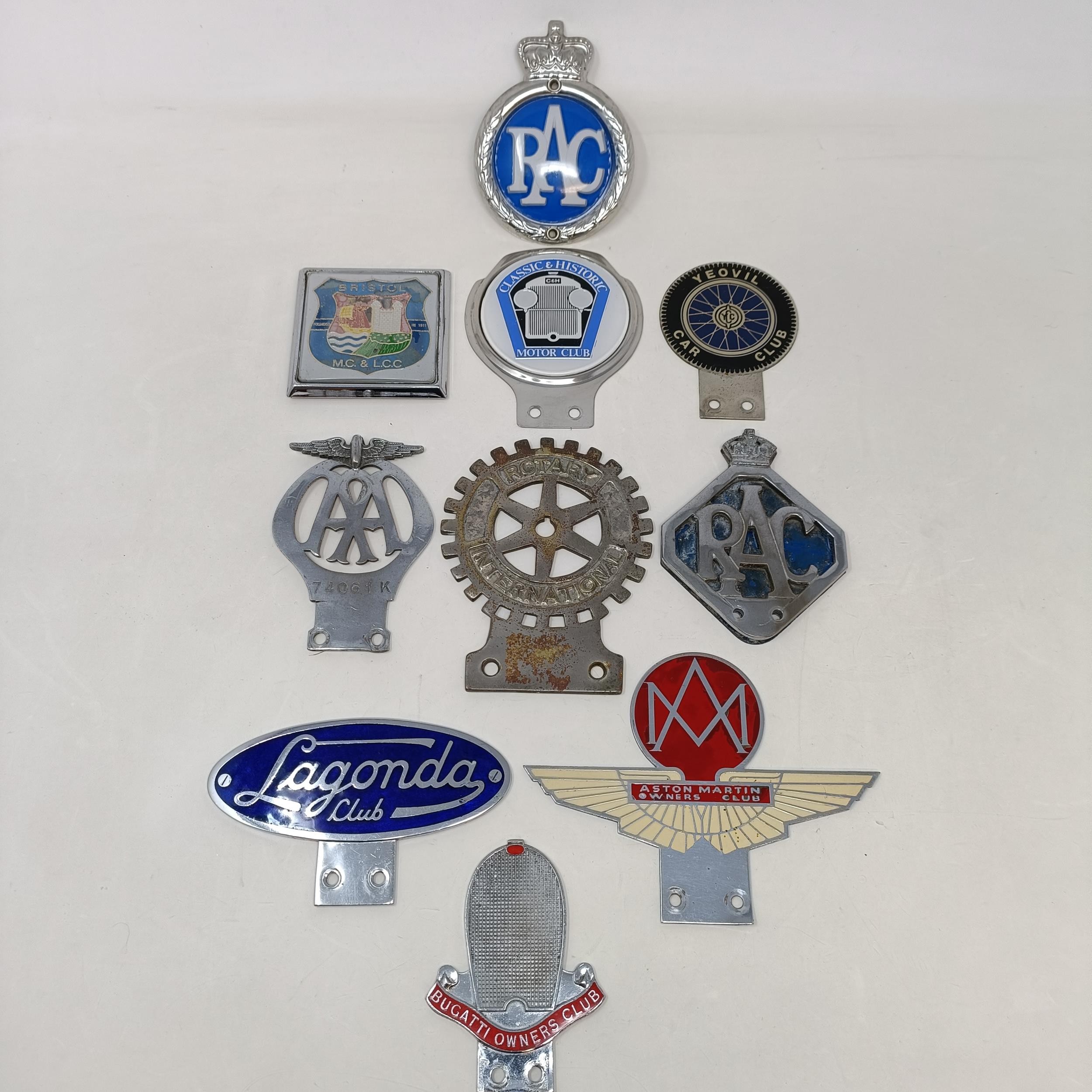 A Lagonda Club car badge, an Aston Martin car badge, and assorted other car badges (box)