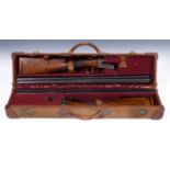 A pair of E J Churchill 20 bore double barrel shotguns, with walnut stocks, in a fitted case.
