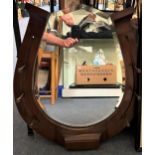 An early 20th century mirror, in the form of a horseshoe in a mahogany frame, 70 x 60 cm Some splits