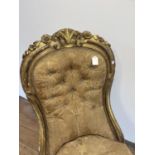 A 19th century gilt framed button back nursing chair Various losses to the wood and the gilt, in