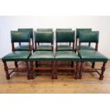 A set of eight oak dining chairs, with padded backs and seats (8) green leatherette