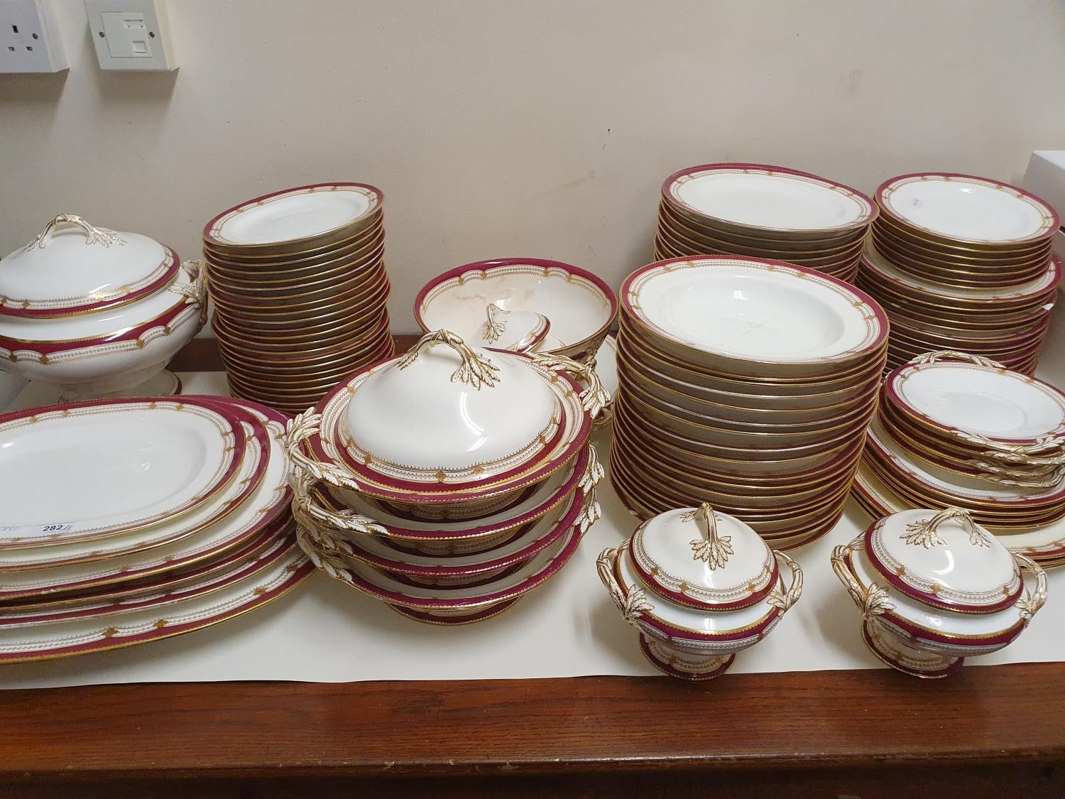 An extensive late 19th/early 20th century dinner service, decorated with a dark pink border,