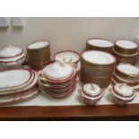 An extensive late 19th/early 20th century dinner service, decorated with a dark pink border,