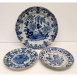 A 19th century Delft plate, 34 cm diameter, and two plates, 23 cm diameter (3) All with various