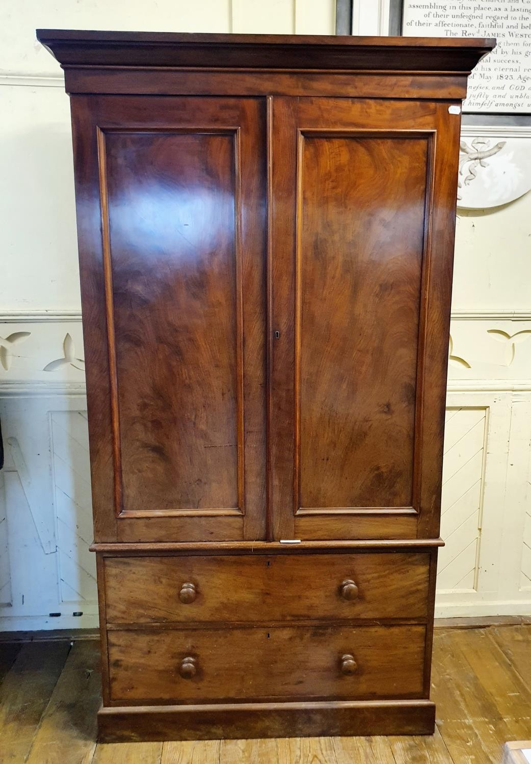 A 19th Century mahogany linen press, two cupboard doors to reveal shelves, on a base with two