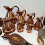 A group of copper harvest type measures, two wooden jigsaw puzzles, a pair of bellows, and other