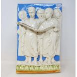 A Continental pottery wall plaque, decorated choristers, 40 x 27 cm Some losses