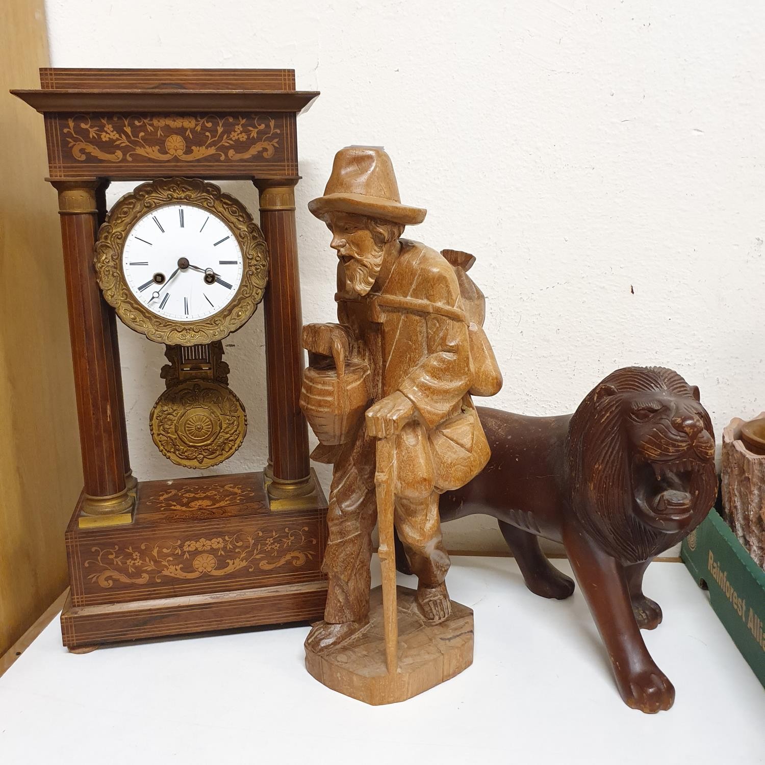 A portico clock, in a rosewood case, 50 cm high, a carved figure of a man, 47 cm high, and a