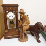 A portico clock, in a rosewood case, 50 cm high, a carved figure of a man, 47 cm high, and a