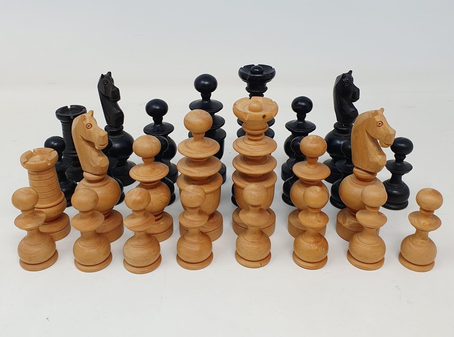 A turned wood chess set, the king being 10 cm high, in a pine box, incomplete Black and white rook