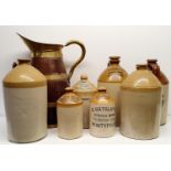 An oak and brass bound jug, 60 cm high, and assorted stoneware bottles (8)