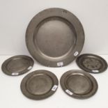 An 18th century pewter plate, 39 cm diameter, and four others, 22 cm diameter (5)