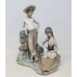 A Lladro group, of a young couple feeding a lamb, 28 cm high No chips cracks or restoration found