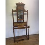 An early 20th century oak hall stand, inset with tiles, decorated flowers, 213 cm high x 85 cm wide