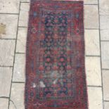 A Persian red ground rug, 189 x 100 cm Poor condition, some losses