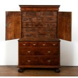 An 18th century walnut cabinet on chest, with two cupboard doors, to reveal an interior with