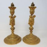 A pair of gilt metal candlesticks, the stems in the form of three putti holding festoons, 28 cm high