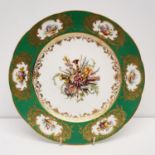 A Sevres style plate, decorated musical instruments and foliage, within a green and gilt border,