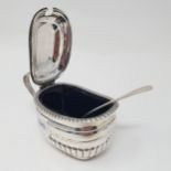 An Edward VII silver mustard pot and spoon, Chester 1902, with a blue glass liner Provenance: From a
