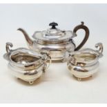 An Edward VII three piece silver tea service, the teapot with wooden handles, Birmingham 1908, all