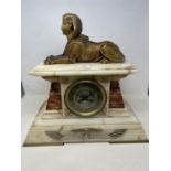 An early 20th century Egyptian revival style mantel clock, the 13 cm diameter silvered dial with