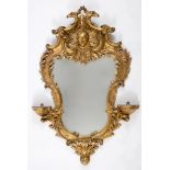 An 18th century style rococo carved giltwood wall mirror, of shaped cartouche form, 113 x 74 cm