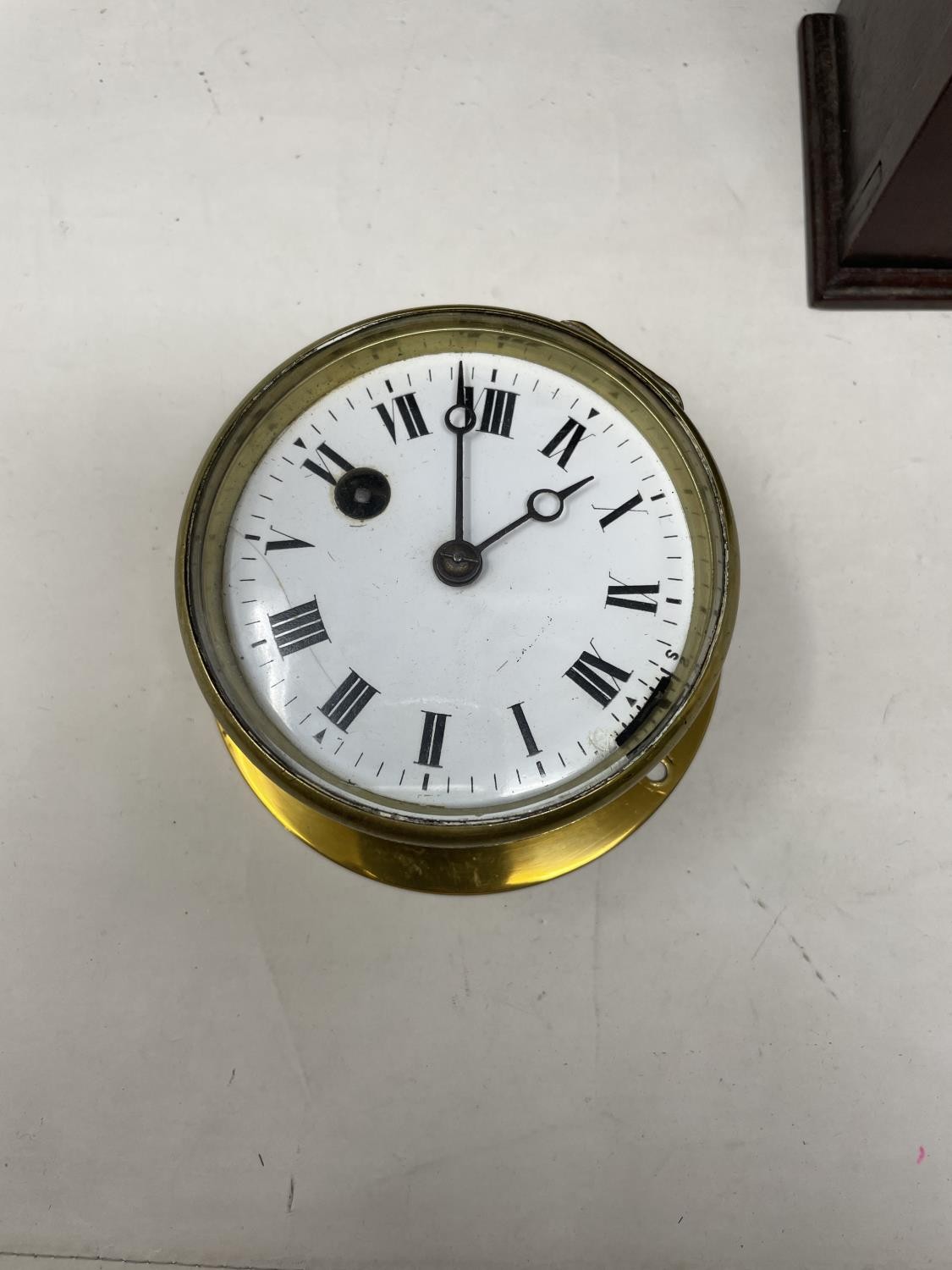 A ship's type bulkhead clock, the 8.5 cm diameter enamel dial with Roman numerals, in a brass - Image 2 of 4