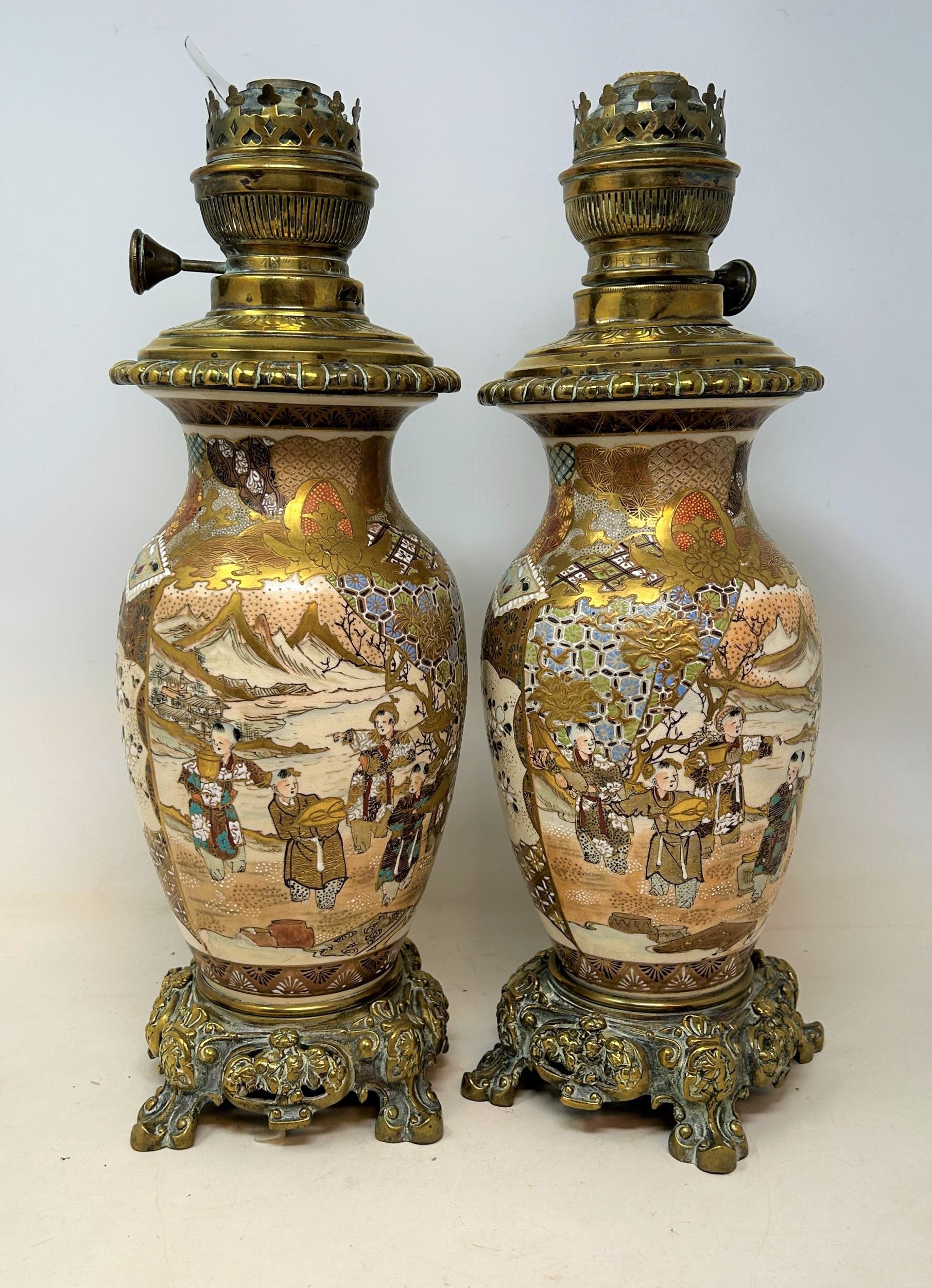 A pair of Satsuma vases, converted to oil lamps, with brass mounts, and glass chimneys, 64 cm high